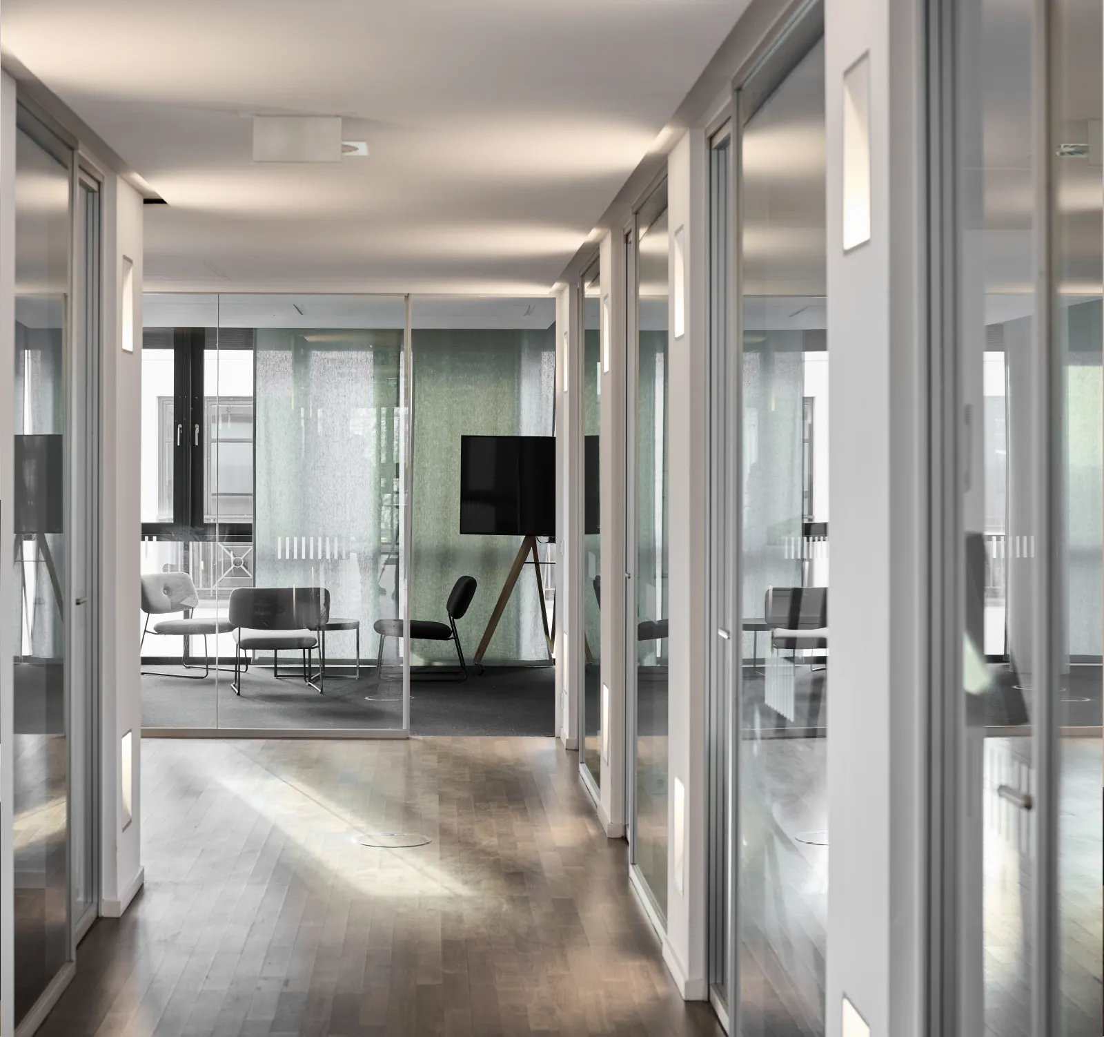 Moderne Büroflächen im Haus H, Westend Ottensen, Hamburg, zeigen eine helle Flurgestaltung mit Glaswänden und gemütlichen Sitzbereichen.